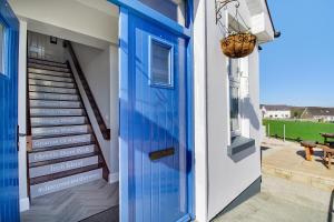 a blue door on a house with a staircase at Inishway self catering apartment 2 in Carndonagh