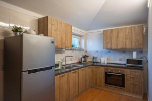 a kitchen with a stainless steel refrigerator and wooden cabinets at Villa Marina in Cava deʼ Tirreni