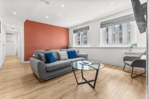 a living room with a couch and a glass table at Heart of the City Centre - Serviced Apartments in Manchester