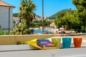 a book on a ledge with a view of a harbor at Hostel EuroAdria in Dubrovnik