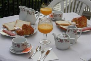 a table with cups and plates of food and orange juice at Pensión Zumardi in Deba