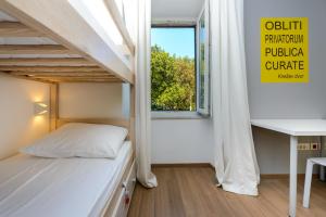 a small bedroom with a bunk bed and a window at Hostel EuroAdria in Dubrovnik