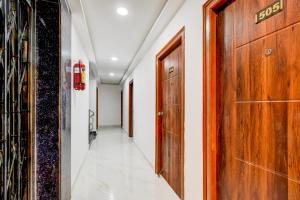 pasillo con puerta de madera y paredes blancas en Super Townhouse JP Nagar Miyapur, en Hyderabad