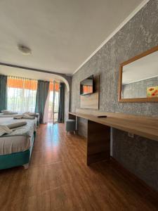 a bedroom with a bed and a desk with a mirror at Hotel Surf Primorsko in Primorsko