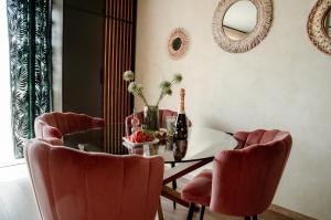 comedor con sillas rojas, mesa y espejo en Happy Home, en Mosonmagyaróvár