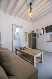 a living room with a table and a refrigerator at Magic holidays 111 in Tourlos