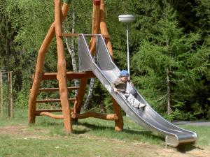 un enfant sur un toboggan dans une aire de jeux dans l'établissement Chalupa U Beranů, à Harrachov