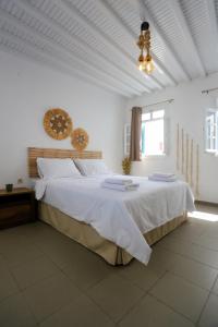 a bedroom with a large bed with white sheets and a chandelier at Magic holidays 111 in Tourlos