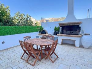 a patio with a table and chairs and a fireplace at Matouli Retreat in Filótion
