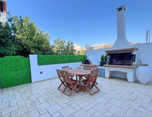 a patio with a table and chairs and a fireplace at Matouli Retreat in Filótion