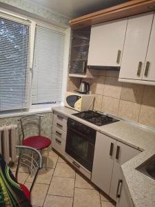 a kitchen with white cabinets and a stove top oven at 2-х комнатная Квартира возле Солнечной галлереи in Yekaterinovka