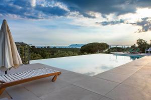 a swimming pool with a bench and an umbrella at Villa Giove 1 in Terracina