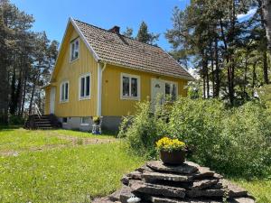 a yellow house with a flower pot in front of it at 4 person holiday home in FÄRJESTADEN in Färjestaden +16 photos