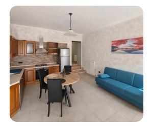 a kitchen and living room with a blue couch and a table at Al BORGO costermano sul garda via pertica 8A in Costermano