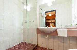 ein Bad mit einem Waschbecken und einem Spiegel in der Unterkunft Armour Motor Inn in Beechworth