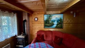 a red couch in a room with a painting on the wall at Holiday Home Stella Star in Žabljak
