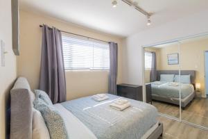 ein Schlafzimmer mit einem Bett und einem Spiegel in der Unterkunft Ocean Beach Bungalow Separate Entry in San Diego