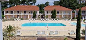 a large building with a swimming pool and a resort at Appartement 2 chambres piscine in Le Verdon-sur-Mer