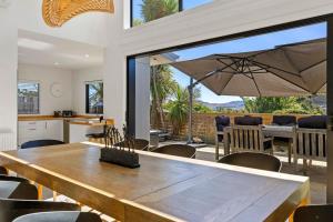 eine Küche und ein Esszimmer mit einem großen Holztisch in der Unterkunft Idyllic Getaway - modern and stylish with private spa in Taupo