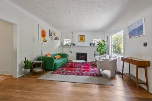 ein Wohnzimmer mit einer grünen Couch und einem Kamin in der Unterkunft Blissful South Hill Retreat in Spokane