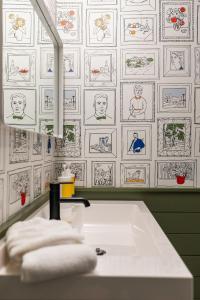 ein Badezimmer mit einem Waschbecken mit Zeichnungen an der Wand in der Unterkunft Blissful South Hill Retreat in Spokane + 74 Fotos