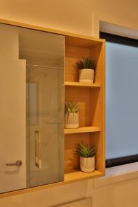 a cabinet with plants in it in a bathroom at Cosy Studio in Awaroa Road in Auckland