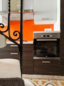 a kitchen with an orange wall and a stove at Casa Maltija in Sliema