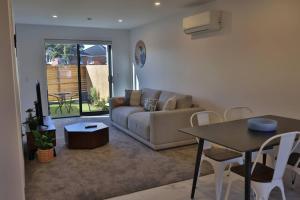 a living room with a couch and a table at Cosy 2BR House in Awaroa Road in Auckland