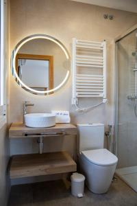 a bathroom with a toilet and a sink and a mirror at O da Sina- Los refugios del capitán AS DE GUÍA in Aldán