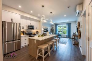 a kitchen with a large island with bar stools at Rivers Edge, Mtn Views, AC, BBQ, King Bed in Golden