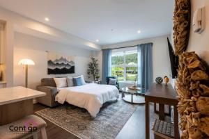 a bedroom with a bed and a couch and a table at Rivers Edge, Mtn Views, AC, BBQ, King Bed in Golden