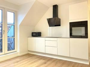 a kitchen with white cabinets and a microwave at Spacious Apartment for 4 in Esbjerg