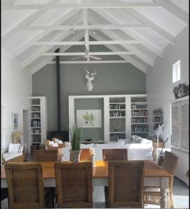 een eetkamer met een houten tafel en stoelen bij Skuurtjie in Prince Albert
