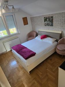 una camera da letto con un letto grande e due sedie di Vila Mirsada a Sarajevo Altre 27 foto