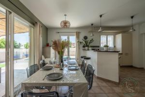 Un comedor con una mesa y una cocina. en Villa ROMARY Piscine & Proche Centre Saint Rémy de Provence, en Saint-Rémy-de-Provence