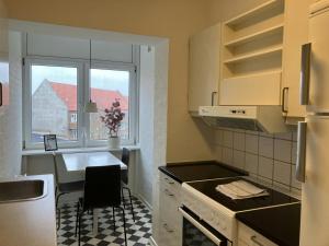 une cuisine avec une table et une cuisinière ainsi qu'une fenêtre dans l'établissement Convenient Studio for 2, à Esbjerg