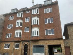 un bâtiment en briques avec des fenêtres blanches sur une rue dans l'établissement Convenient Studio for 2, à Esbjerg 6 autres photos