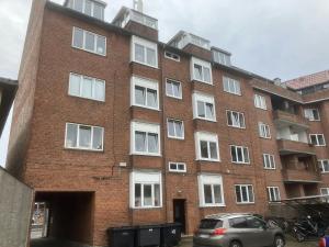 un bâtiment en briques avec une voiture garée devant dans l'établissement Convenient Studio for 2, à Esbjerg