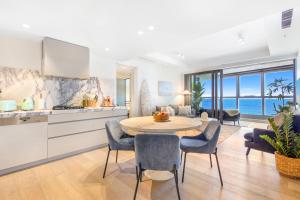 een keuken en woonkamer met een tafel en stoelen bij Sapphire Oceanview Suite in Gold Coast +34 foto's