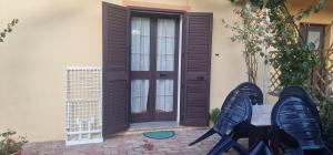 a door to a house with two chairs and a table at Appartamento1 in San Teodoro
