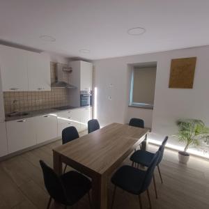 a kitchen and dining room with a wooden table and chairs at Apartma Zala in Šmarje +6 photos