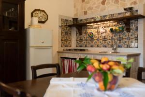 a kitchen with a table and a counter with a refrigerator at Agriturismo La Stornara, Petfriendly & EV Friendly in Ginosa Marina