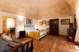 a bedroom with a bed and a couch in a room at Agriturismo La Stornara, Petfriendly & EV Friendly in Ginosa Marina