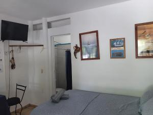 a bedroom with a bed and pictures on the wall at Affordable, Comfortable, and Convenient – Barcos in Manzanillo