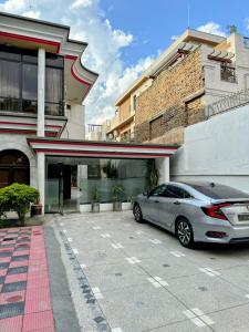 a car parked in a parking lot in front of a building at Casa Blanca Family Lodges in Islamabad +36 photos
