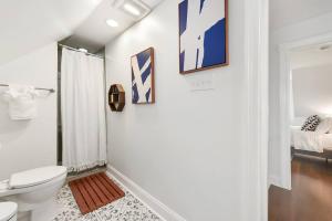 a white bathroom with a toilet and a shower at The Point State Room on Beatty in Pittsburgh