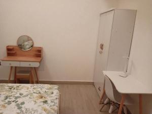 a bedroom with a bed and a desk and a dresser at Quiet Haven Peaceful Room in Ajman 
