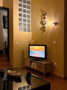 a living room with a flat screen tv on a table at Caramel Cloud in Mytilene