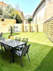 un patio avec une table et des chaises sur l'herbe dans l'établissement Villa CANA, à Cannes
