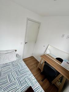 a bedroom with a bed and a desk with a keyboard at Apartamento aconchegante e moderno com varanda na Rua Guaicurus in Sao Paulo